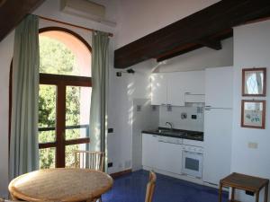 a kitchen with white appliances and a table and a window at Quinta holiday residence in Rio nell'Elba in Rio nellʼElba