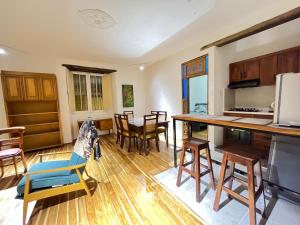 cocina y sala de estar con suelo de madera y encimera en La Casa Azul del Ventorrillo: Hospedaje Historico en Bogotá