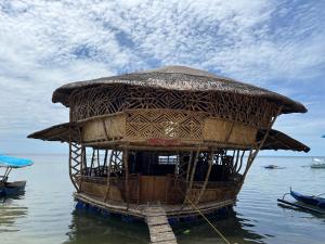 una pequeña cabaña en el agua en el agua en Bamboo Nest Beachfront Floating Tent, en Puerto Princesa City