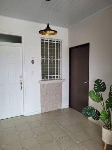 einen Flur mit Tür und Topfpflanze in der Unterkunft Acogedor apartamento in San Miguelito