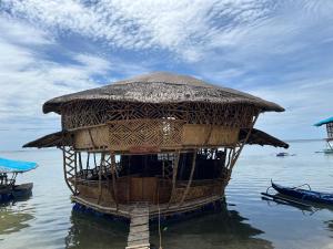 a hut in the water in the water at Bamboo Nest Beachfront Floating Tent in Puerto Princesa City