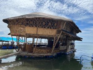 eine Hütte auf dem Wasser im Wasser in der Unterkunft Bamboo Nest Beachfront Floating Tent in Puerto Princesa