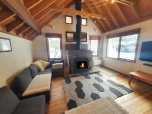 a living room with a couch and a fireplace at SNOWED INN apartment in Dinner Plain