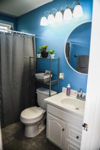 a bathroom with a toilet and a sink and a mirror at 5 Star with Direct Access to Brimstone Recreation Game Room Comfortable Up to 4 Bedrooms Stylish in Huntsville