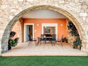 a patio with an archway and a table and chairs at Luxury Villa in Kalamitsi Alexandrou in Kalamítsion Alexándrou