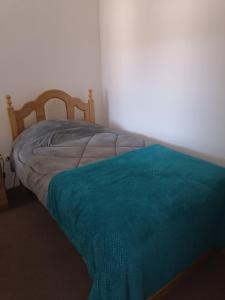 a bedroom with a bed with a blue blanket on it at Departamento Condominio Magisterio in Talca