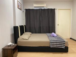 a bed sitting in a room with a window at KK City Api Api Apartment beside Centre Point by JR Homestay in Kota Kinabalu