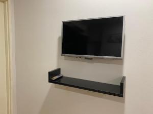 a flat screen tv hanging on a wall at KK City Api Api Apartment beside Centre Point by JR Homestay in Kota Kinabalu