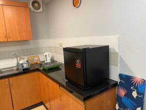 a kitchen with a black refrigerator on a counter at KK City Api Api Apartment beside Centre Point by JR Homestay in Kota Kinabalu