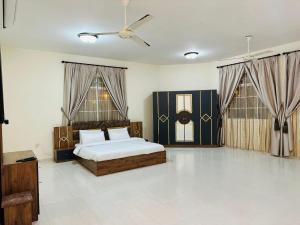 a bedroom with a bed and a ceiling fan at البيت الأبيض للشقق المفروشة White House in Salalah