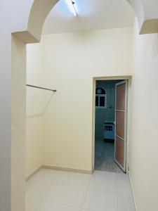 um quarto vazio com uma escada e uma cozinha em البيت الأبيض للشقق المفروشة White House em Salalah