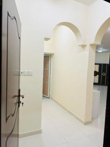 a hallway with a glass door in a building at البيت الأبيض للشقق المفروشة White House in Salalah