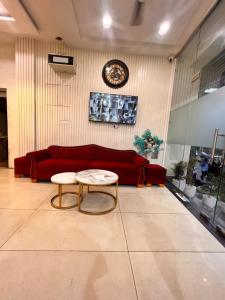a living room with a red couch and a table at HOTEL KINGS in Pānīpat