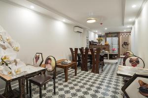 Una sala de estar con mesas y sillas y una cocina. en Narcissus 2 Hotel & Apartment, en Hanói