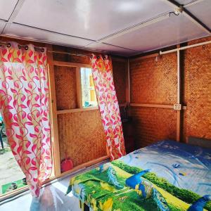 a small room with a bed and curtains at Beyond Brahmaputra & Eagles Nest 