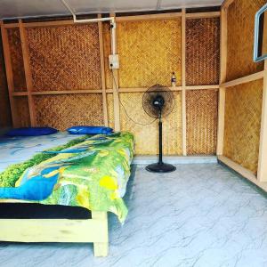 a bedroom with a bed and a fan in a room at Beyond Brahmaputra & Eagles Nest 