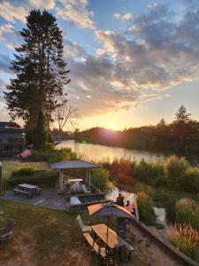 un gruppo di persone seduti sotto gli ombrelloni vicino a un fiume di Campbell River Lodge a Campbell River Altre 37 foto