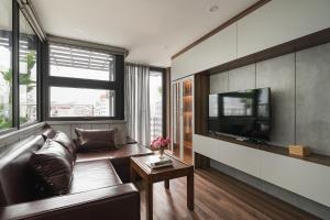Una sala de estar con un sofá y un televisor de pantalla plana. en Narcissus 2 Hotel & Apartment, en Hanói