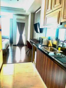 a kitchen with a sink and a living room at Panbil Residence Apartment Batam in Kangboi