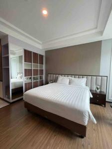 a bedroom with a large white bed and a mirror at Apartment Panbil with Gym & Pool #Unit 603 in Nagoya +7 photos