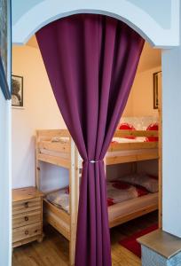 リーガースブルクにあるFerienwohnung Familie Hartingerの二段ベッド付きの客室で、紫色のカーテンが備わります。