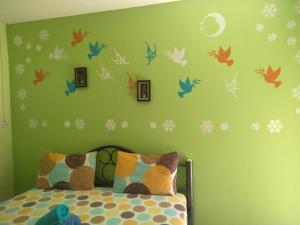 - une chambre dotée d'un mur vert avec des décalcomanies d'oiseaux dans l'établissement Adrian View resort, à Ko Sichang
