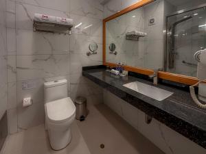 a bathroom with a toilet and a sink and a mirror at MIRAFLORES CITY HOTEL in Lima
