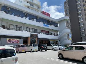 北谷町米哈美克公寓式酒店的建筑物前停放汽车的停车场