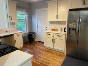 a kitchen with white cabinets and a stainless steel refrigerator at Boston Luxury Condo Style Rooms in Boston
