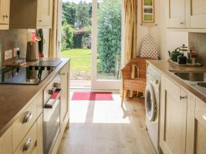 una cocina con lavadora y secadora. en Stable Cottage, en Belford