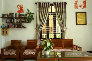 Hoi An Holiday Villa في هوي ان: غرفة معيشة مع طاولة وكراسي ونافذة