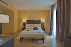 a bedroom with a bed and a large window at Zen Hotel Versilia in Marina di Pietrasanta