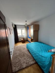 a bedroom with a bed with a blue comforter at Apartament Central Plaja Modern in Constanţa