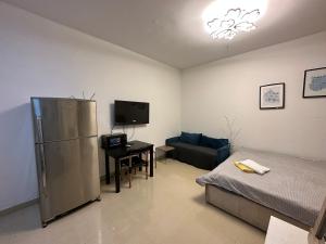 a living room with a refrigerator and a couch at Khalidiya Studio Villa 6 Room 13 Abu Dhabi UAE in Abu Dhabi