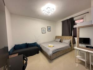 アブダビにあるKhalidiya Studio Villa 6 Room 13 Abu Dhabi UAEのリビングルーム(ベッド1台、ソファ付)