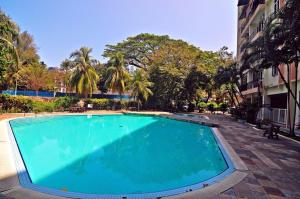 a large blue swimming pool next to a building at My Cozy Nest - Near Beach in Batu Ferringhi