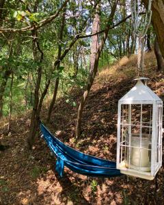 a blue hammock with a lantern in the woods at Karavan Na Louce in Volenice