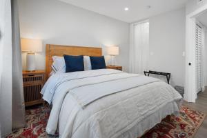 um quarto branco com uma cama grande e almofadas azuis em Premier 1BR w/Bath in the Center of Culver City em Los Angeles