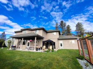 a house with a fence in a yard at Green Leaf B&B in West Kelowna