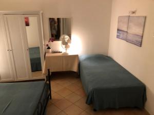 ヴォラストラにあるIl Cortile del Contadinoのベッド2台、テーブル(ランプ付)が備わる客室です。