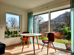 a table and chairs in a room with a large window at Ferienappartement am Slevogtweg in Leinsweiler