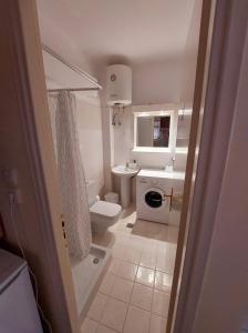 La petite salle de bains est pourvue de toilettes et d'un lavabo. dans l'établissement Eleni's Apartments Igoumenitsa -- Γκαρσονιέρα 1ου ορόφου επιπλωμένη, εξοπλισμένη, à Igoumenítsa