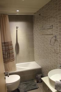 a bathroom with a tub and a toilet and a sink at Villa Rododafni in Roda +26 photos