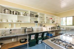 a kitchen with white shelves and a sink at Bay of Islands Lodge in Paihia