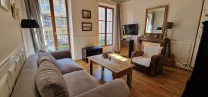 a living room with a couch and a table at Atout Charme in Versailles