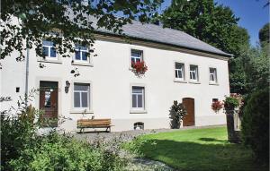 a white house with a bench in front of it at Holiday Home Braunlauf 03 in Braunlauf
