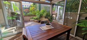 a balcony with a wooden table and potted plants at Atout Charme in Versailles