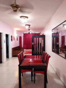 a dining room with a table and red chairs at Ct Homestay Pelangi Mall Kota Bharu in Kota Bharu
