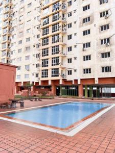 a swimming pool in front of a large building at Ct Homestay Pelangi Mall Kota Bharu in Kota Bharu