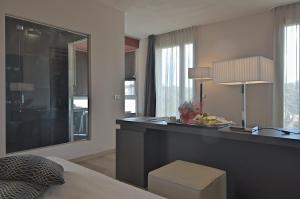 a kitchen with a counter with a stool in a room at Zen Hotel Versilia in Marina di Pietrasanta